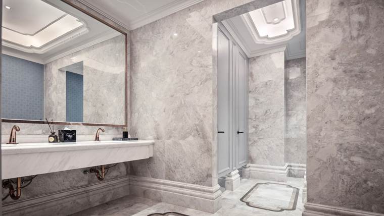 Marble restroom with a wall-hung sink and open space underneath