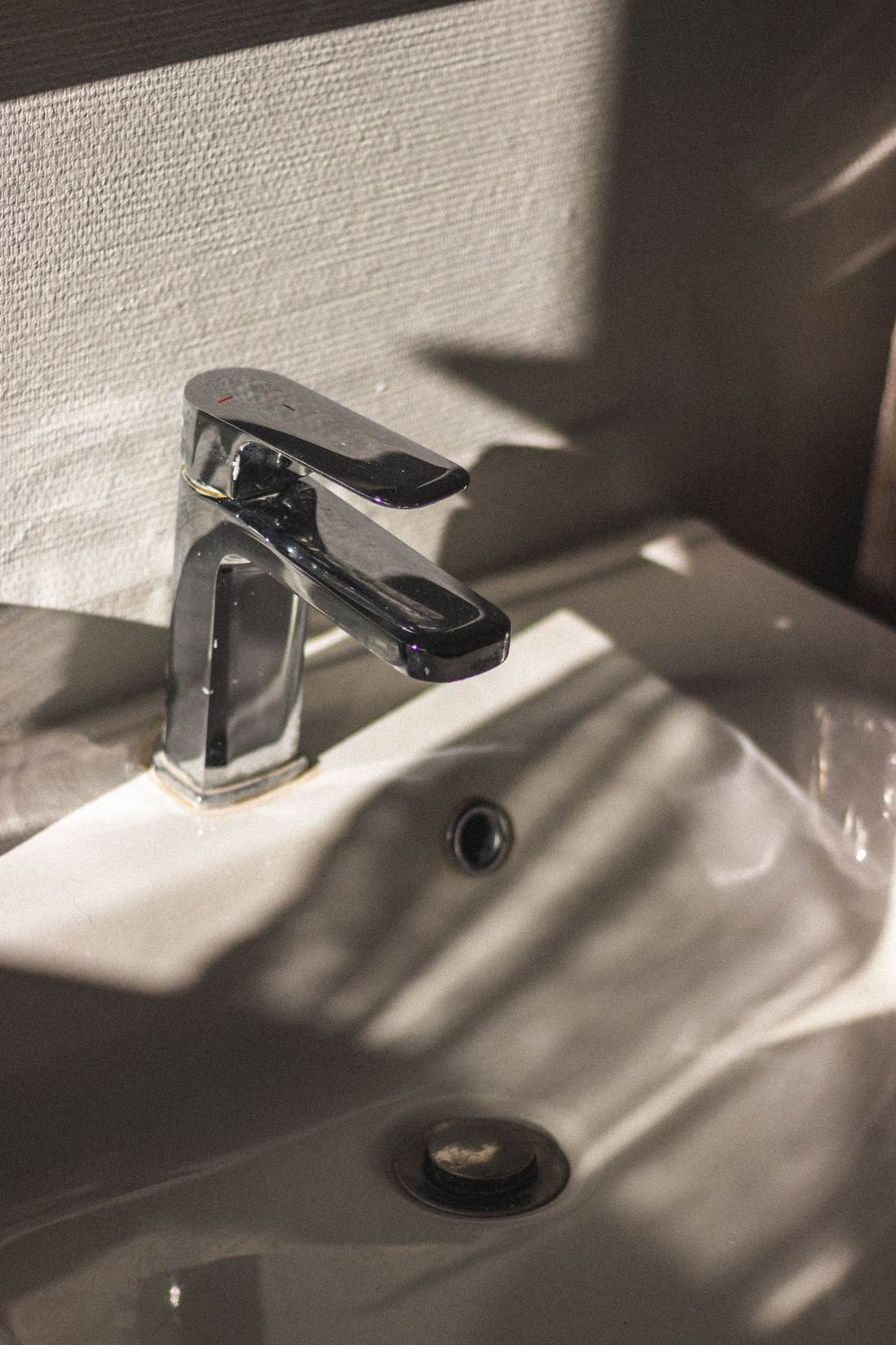 Chrome single-handle bathroom faucet over a white sink