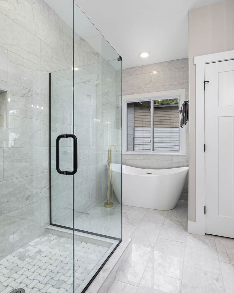 Bathroom remodeling idea: walk-in shower with a frameless glass enclosure, tiled niche, and freestanding tub