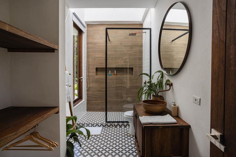 Tiled curbless shower with wood-look porcelain walls, a long recessed niche and a black-framed glass panel