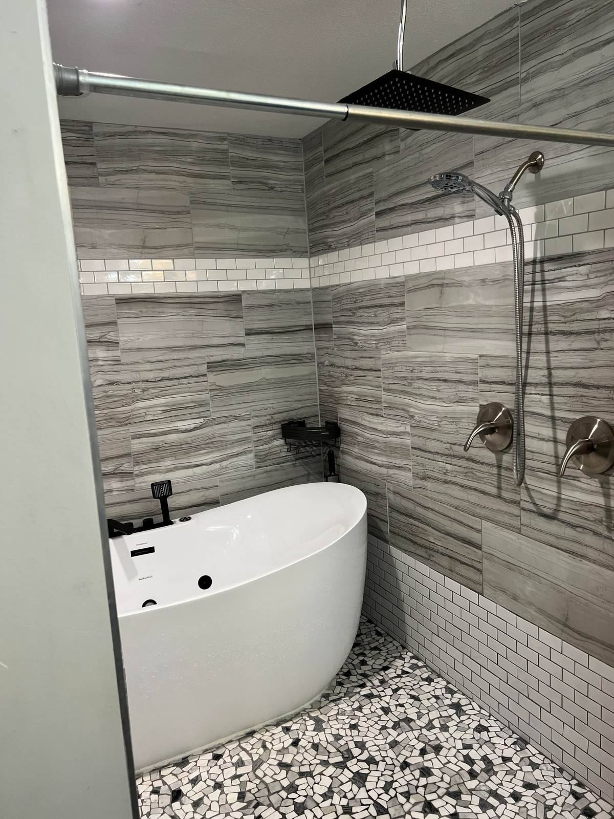 Handheld shower on the wet room wall beside the freestanding tub in the Tulsa remodel