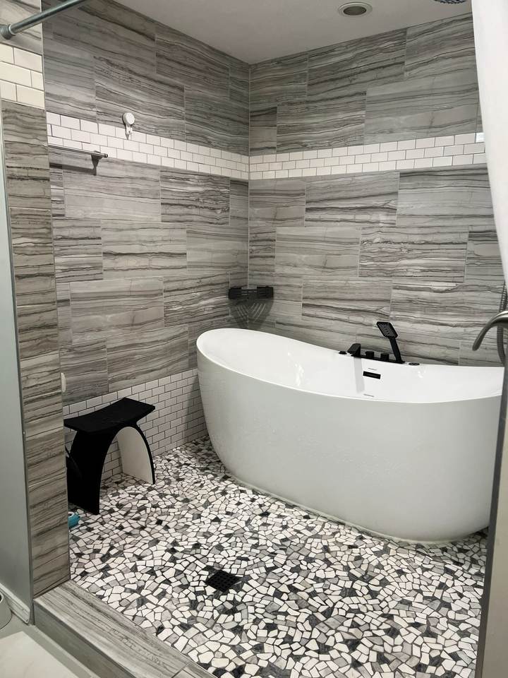 White soaking tub with black fixtures in the finished south Tulsa wet room