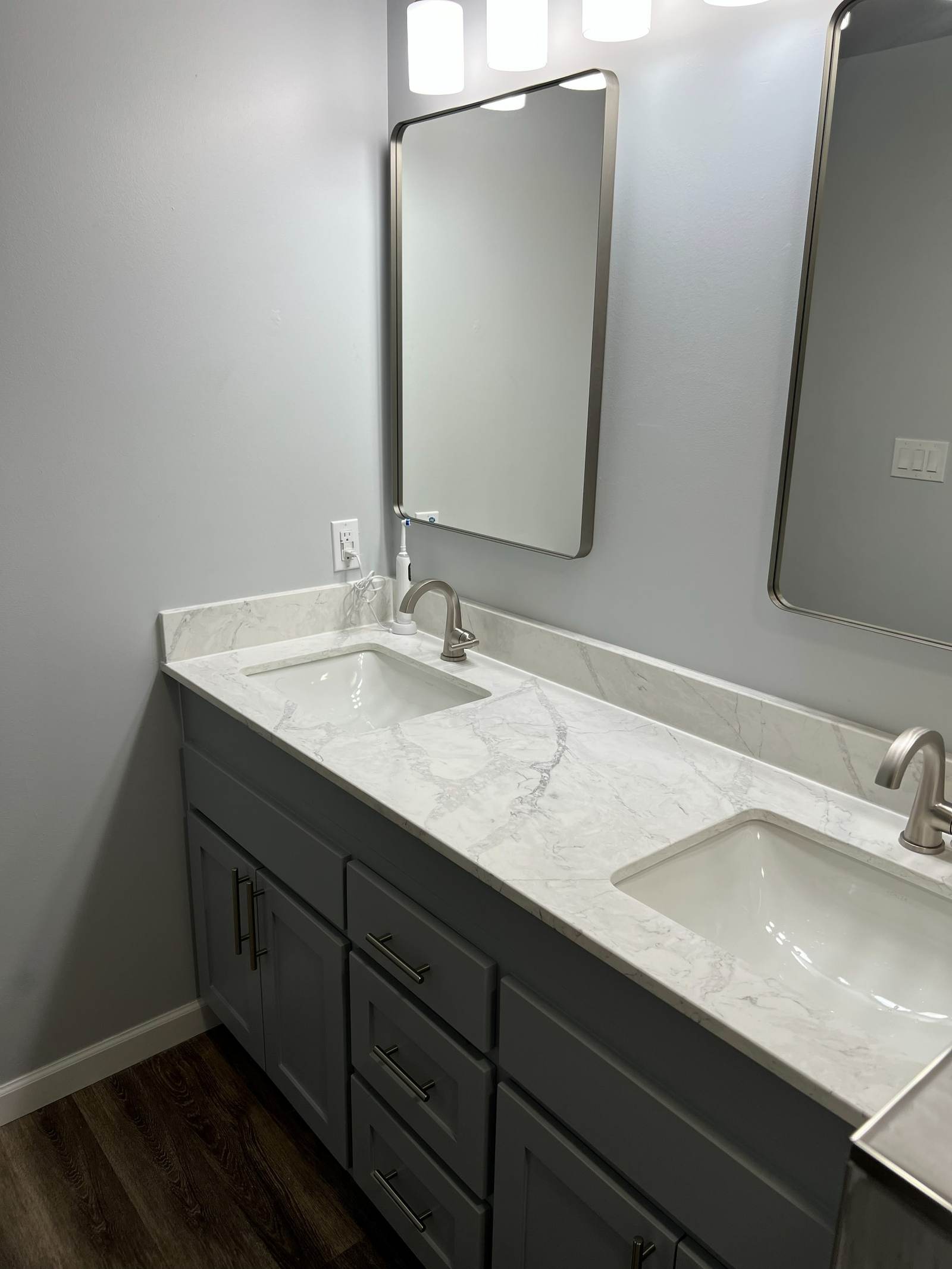 Gray double vanity with a marble-look top over a wood-look vinyl plank floor, in an east Tulsa master bath we remodeled