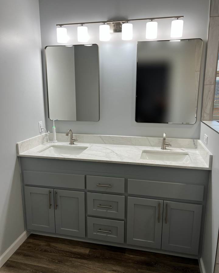 A gray shaker double vanity with a marble-look top and two mirrors
