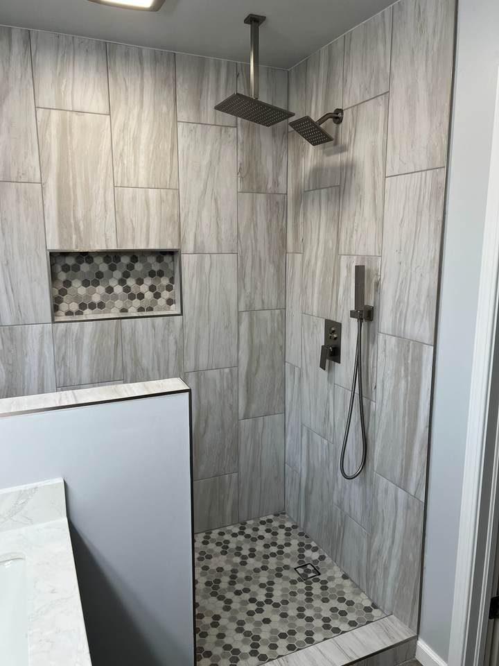 Rain head and handheld shower with matte black trim on wood-look gray tile in the new Tulsa shower