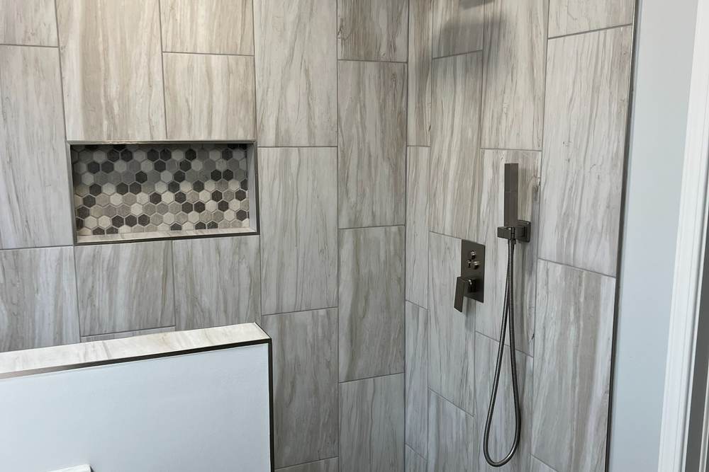 Rain head, hand shower and a new matte black valve trim on wood-look gray tile, in the shower we built where a jetted tub stood in an east Tulsa master bath
