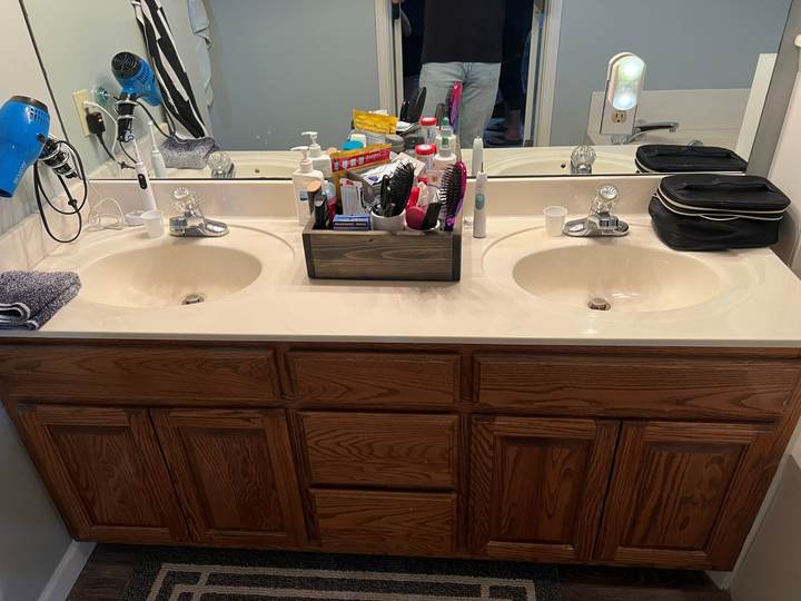 Before: the oak double vanity with a cultured-marble top in the Tulsa master bathroom