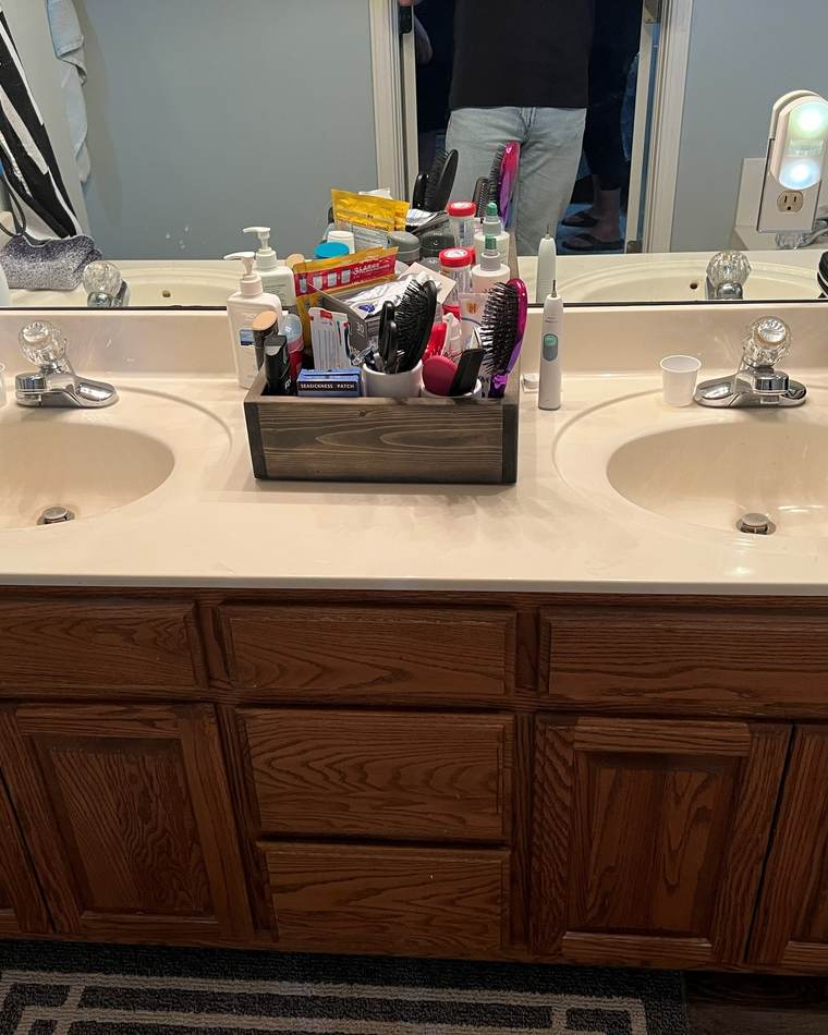 Before: an oak double vanity with a cultured-marble top and two sinks