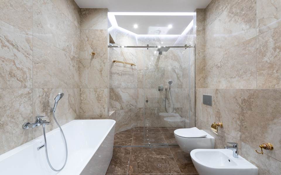 Marble-look bathroom with a soaking tub beside a glass walk-in shower