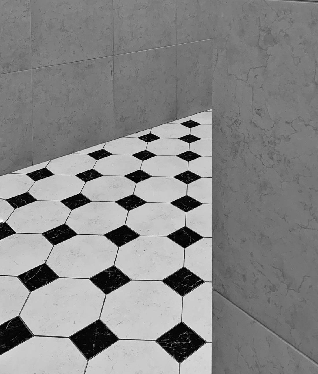 Black and white octagon floor tile meeting a gray wall