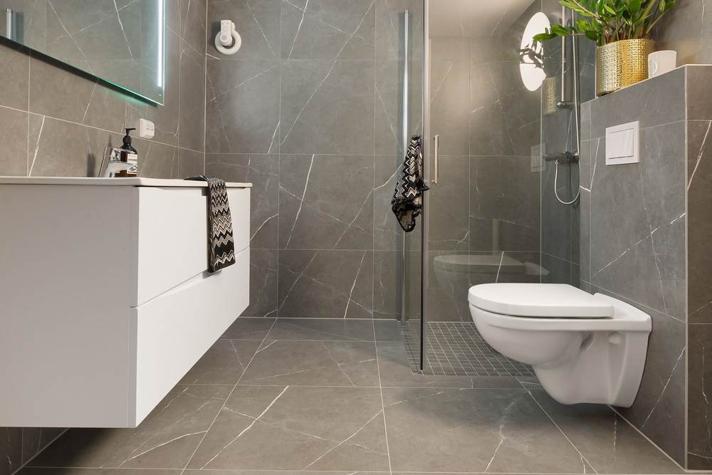 Large-format porcelain floor tile in a restroom with thin grout joints