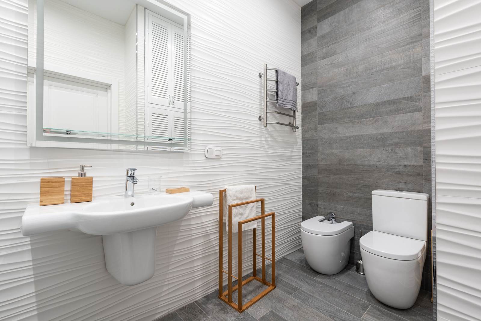 Modern bathroom with a toilet and a bidet side by side beside a sink