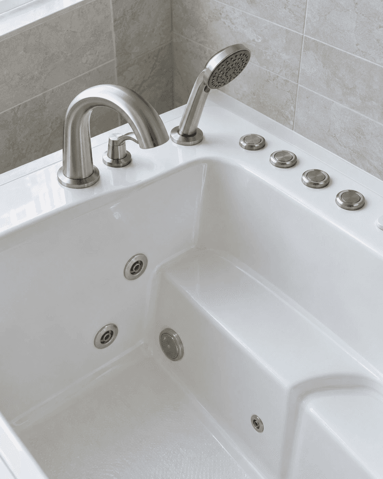 Walk-in tub faucet, hand shower and control buttons on the rim, within reach of the built-in seat
